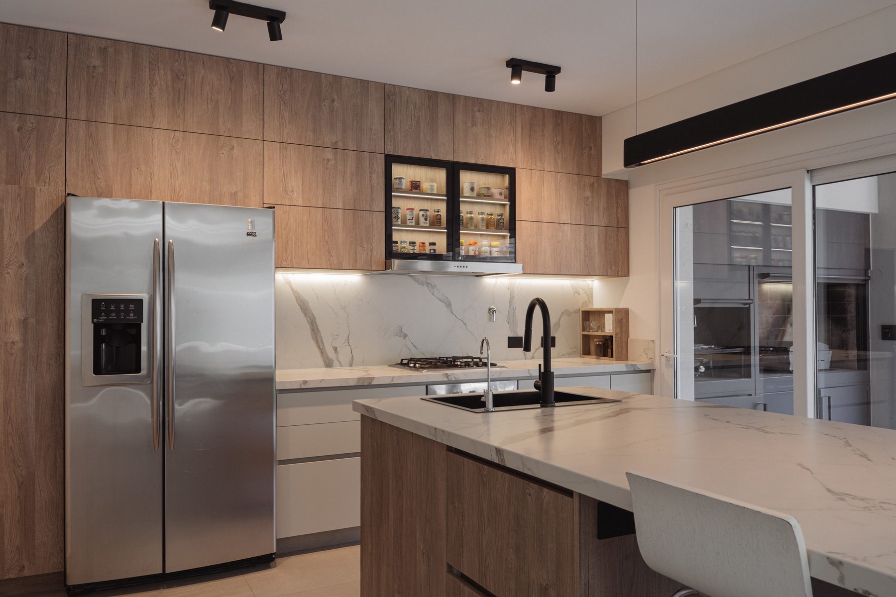 Cocina del Proyecto Martínez, isla con vitrina iluminada