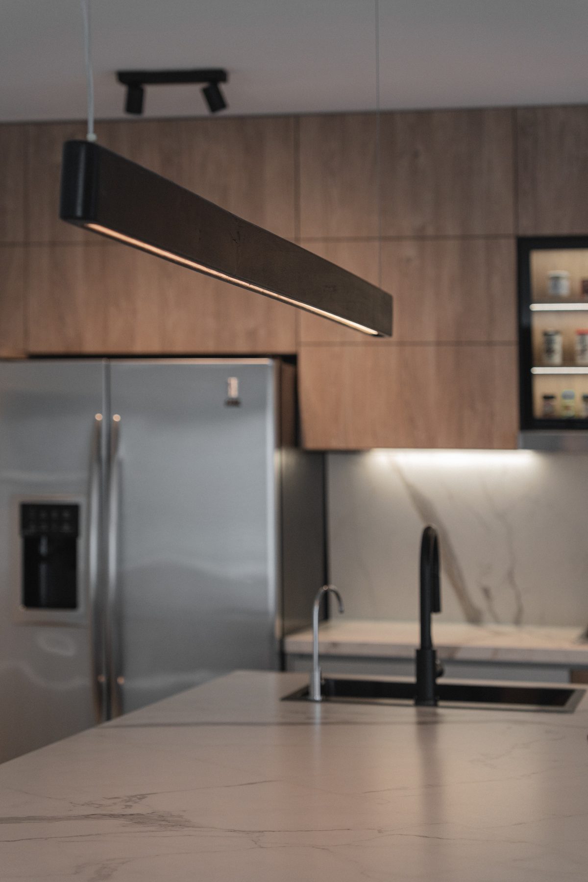 Cocina del Proyecto Martínez, vista general con heladera y luz colgante